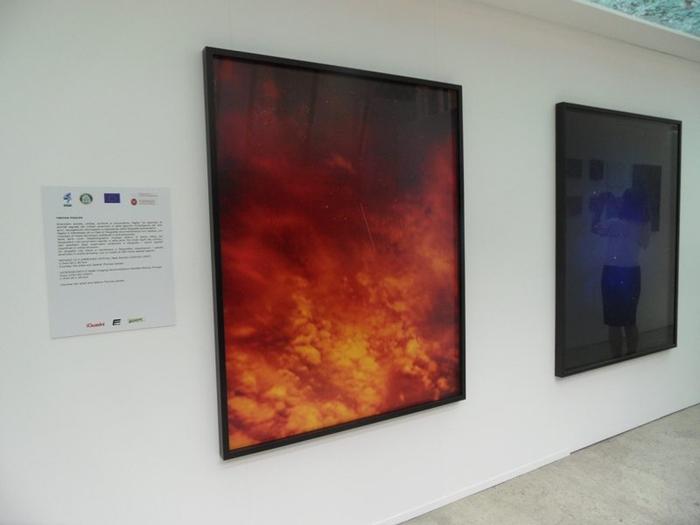 Due fotografie incorniciate di Trevor Paglen accanto al pannello descrittivo