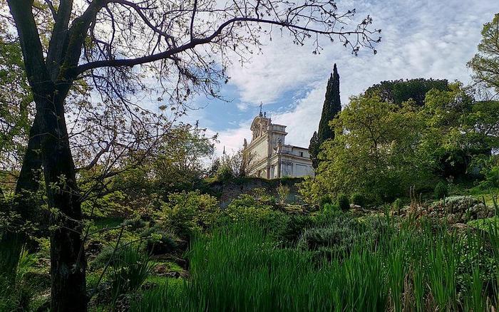 Vegetazione del giardino botanico con un edificio storico sullo sfondo