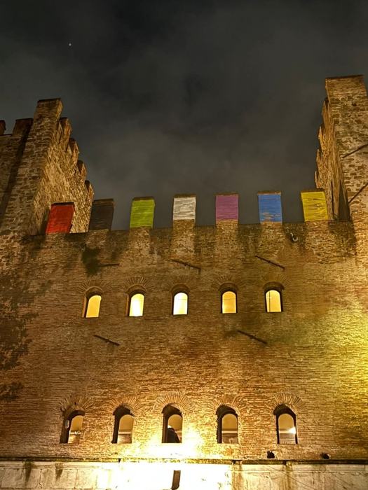 The gate tower lit at night, with coloured elements on the battlements