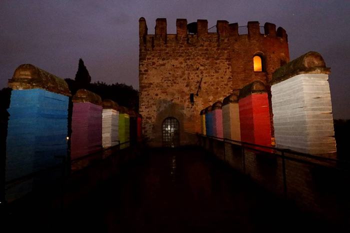 Walkway on the walls with columns wrapped in coloured bands, and a tower at the end