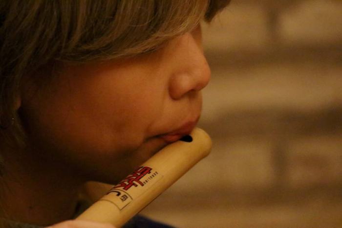 Close view of a performer playing a small flute