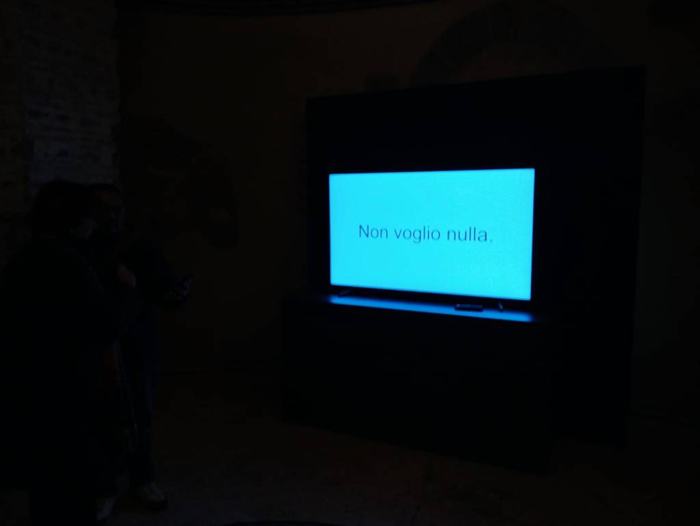 A screen in a dark room showing a blue frame with white text