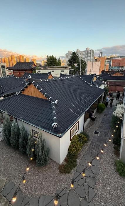 View from above over traditional tiled rooftops and a courtyard with string lights
