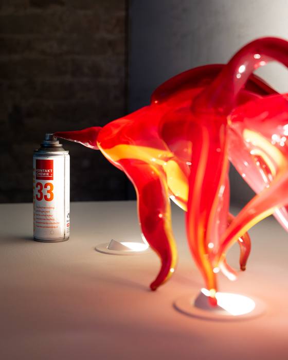 Detail of a red and orange glass sculpture with flame-like forms