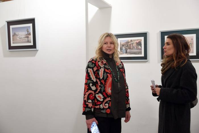 Camilla Boemio conversa con una visitatrice davanti alle fotografie in mostra
