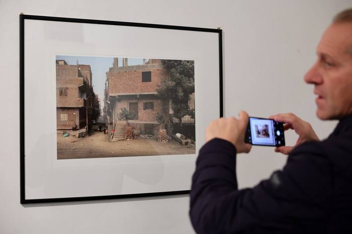 Camilla Boemio conversa con un visitatore davanti a fotografie incorniciate durante l&rsquo;inaugurazione