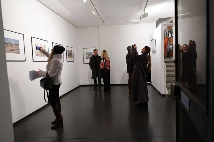 Un visitatore fotografa con il telefono una fotografia incorniciata di una via del Cairo