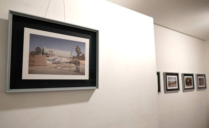 Fotografia incorniciata in primo piano con altre stampe allineate lungo il corridoio della galleria